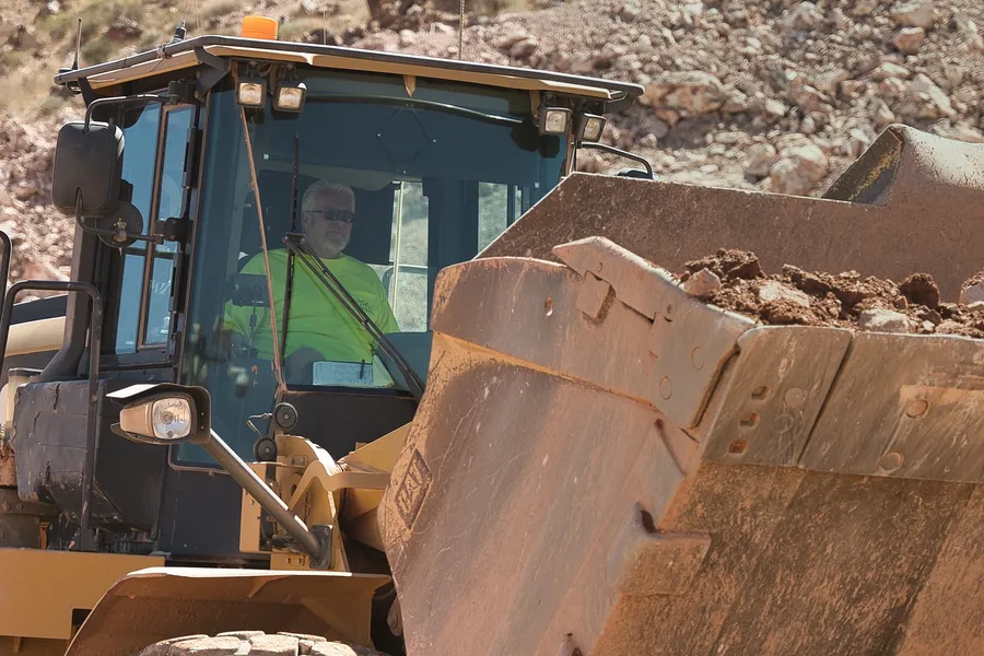 worker loading aggregate material into haul truck at southern nevada quarry